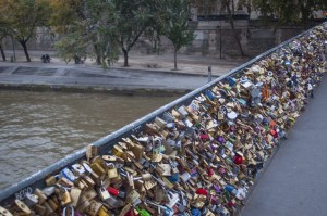 Locks lining the rails of a bridge along the River Seine